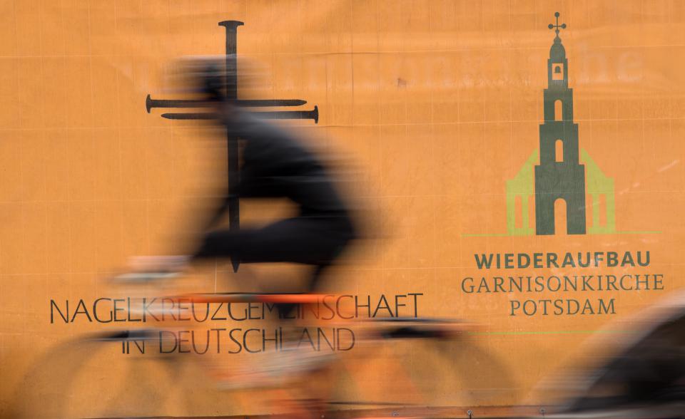  Ein Radfahrer fährt in Potsdam am Logo des Wiederaufbaues der Garnisonkirche vorbei 